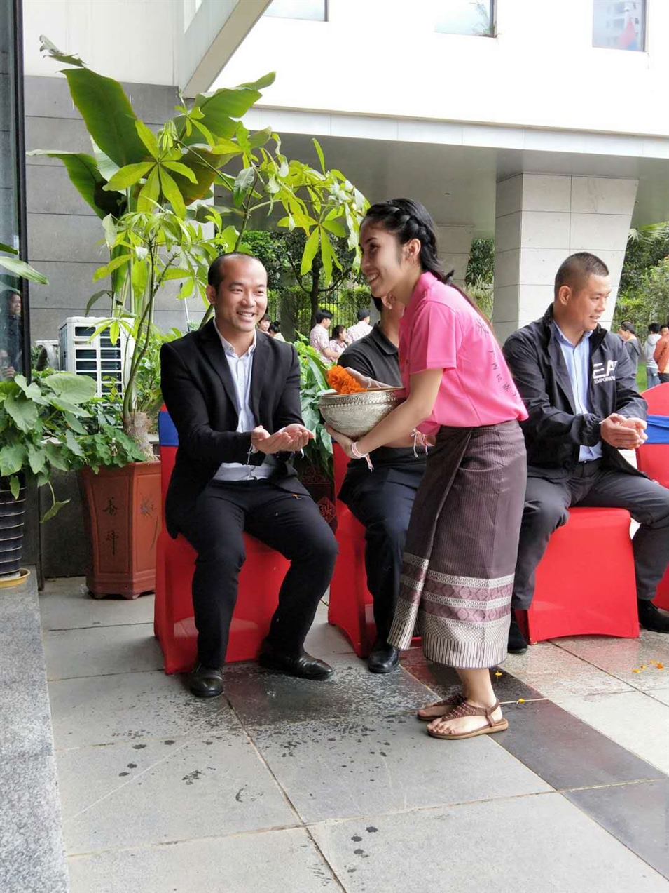 老撾駐廣西留學(xué)生代表將浸有花瓣的香水灑客人的手上，表示對(duì)嘉賓的美好祝福（圖一）